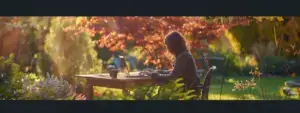 a person using a laptop outdoors with a beautiful garden in the background.